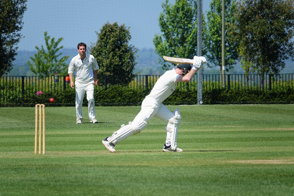 two men playing a game of cricket on a field