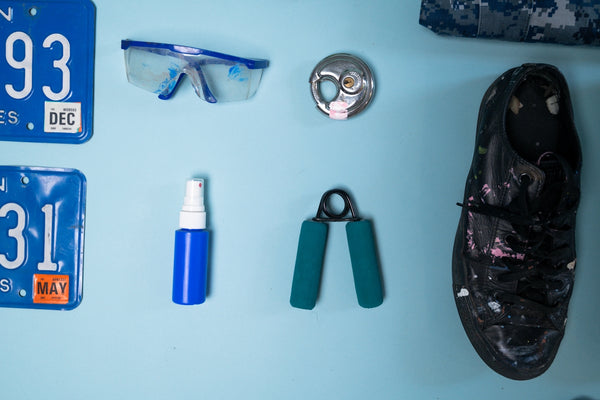 Goggles, license plates, shoe, and fitness equipment laid out.