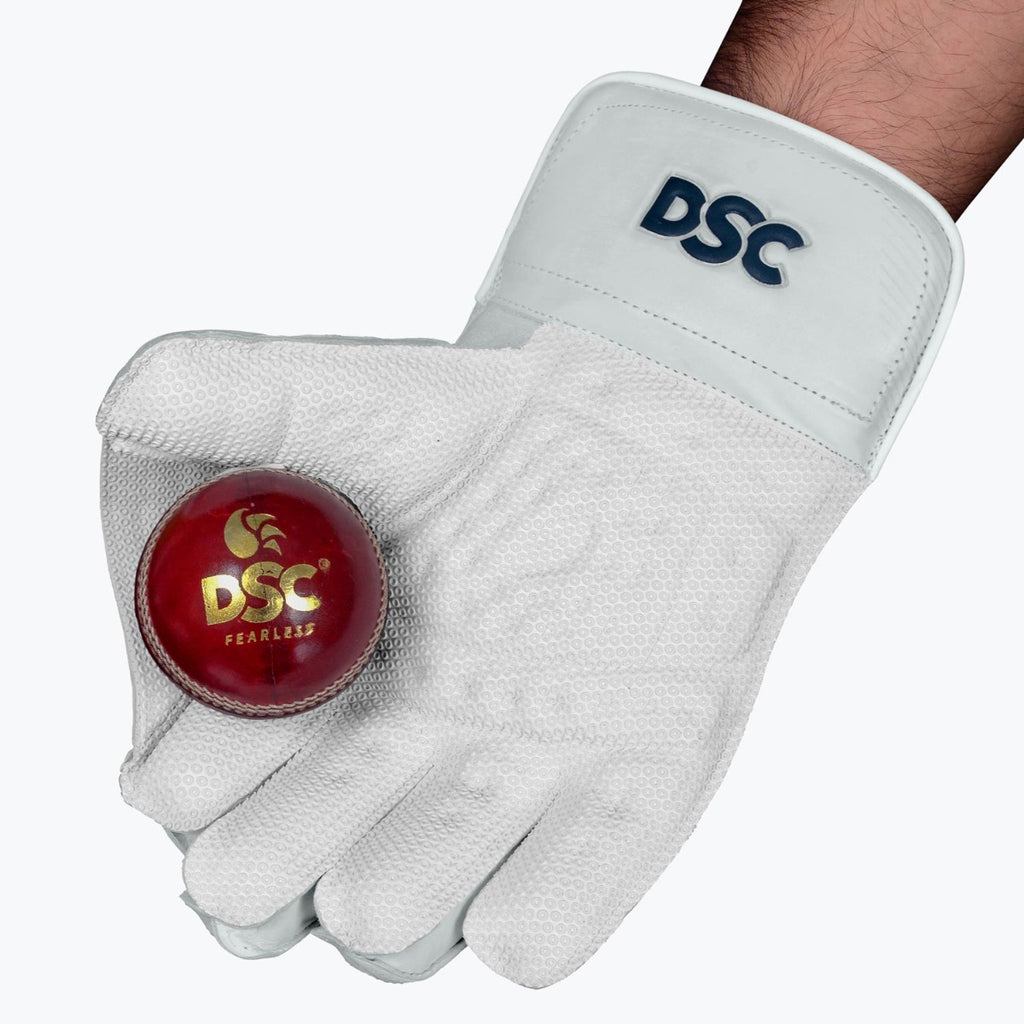 DSC Intense Pro adult wicketkeeping glove holding a red cricket ball in the catching palm